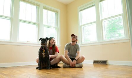woman in gray shirt sitting on brown wooden floor